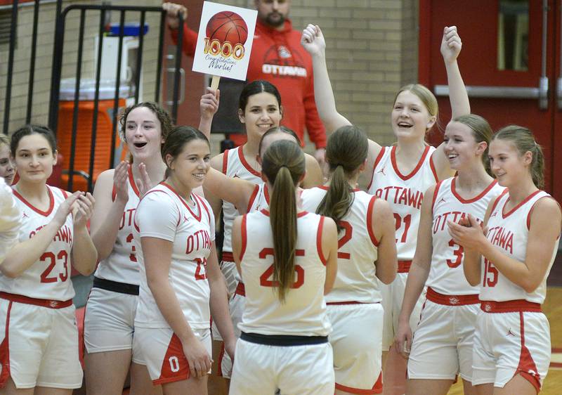 The Pirates congratulate their teammate Marlie Orlandi after she scored her 1,000-point Thursday night against Streator at Ottawa.