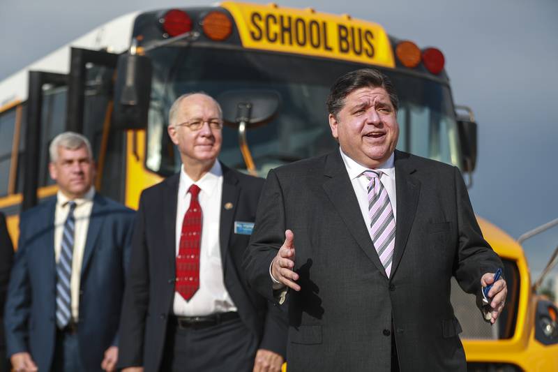 Illinois Governor J.B. Pritzker (right), U.S. Rep. Bill Foster, D-Naperville (center), and Joliet Mayor Bob O'Dekirk (left) address the media during a press conference on Friday, May 7, 2021, at 3835 Youngs Road in Joliet, Ill. Governor Pritzker announced at a press conference on Friday morning that Lion Electric will be building a factory to produce electric school buses in Joliet. This will be the company's first factory in the United States.