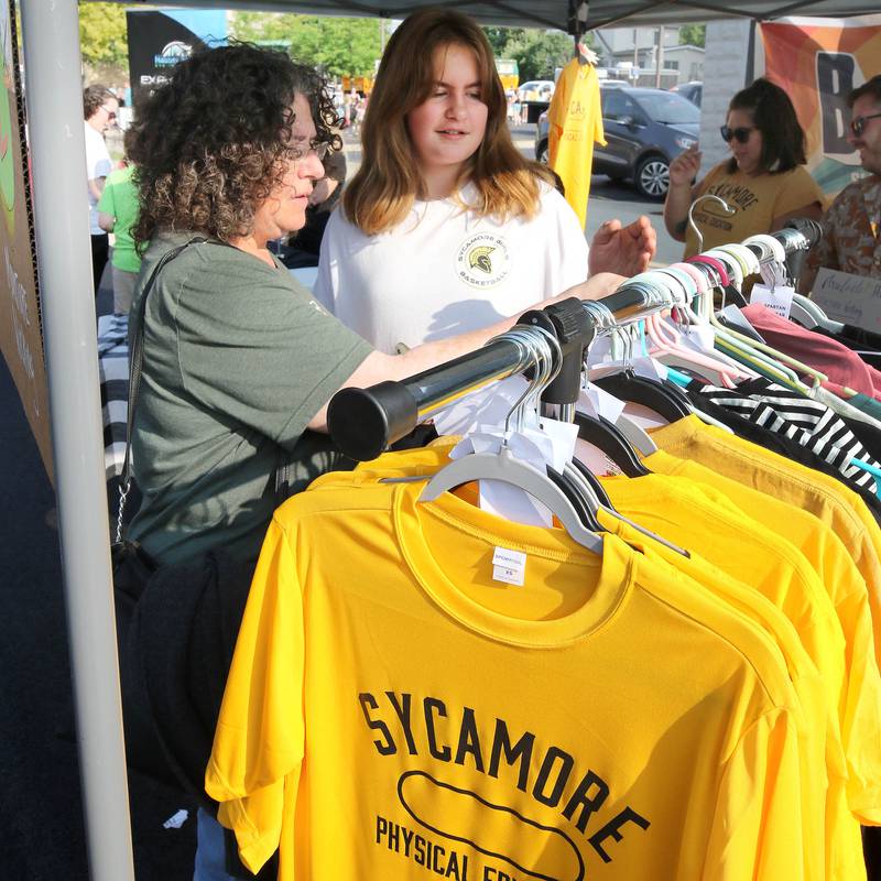 Angela Dowat, and her daughter Chloe, who will be a sixth-grader in Sycamore this year, look at some shirts during Sycamore Community School District 427’s Back2School Bash Tuesday, Aug. 8, 2023 in downtown Sycamore. The event featured vendors offering activities, food and games to celebrate the return to school.
