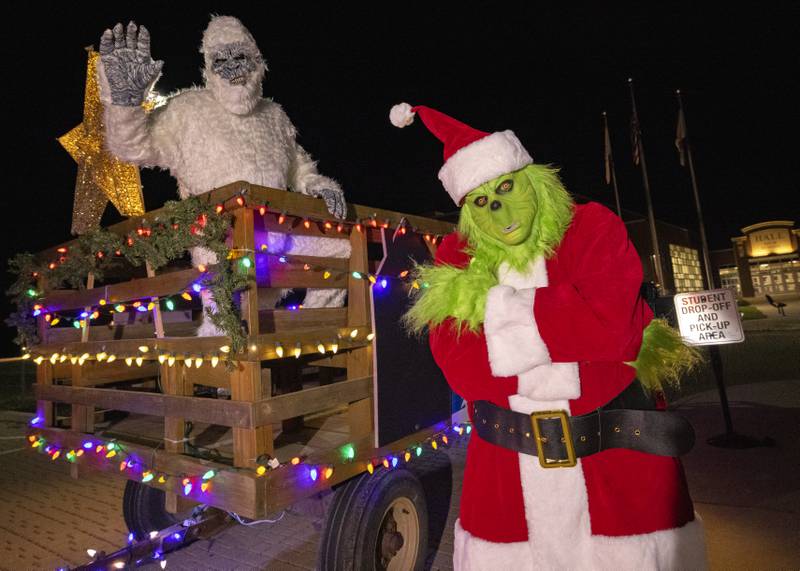 The Grinch and a Yeti, two of the characters in the parade pose prior to the start of the event in Spring Valley on November 25, 2023