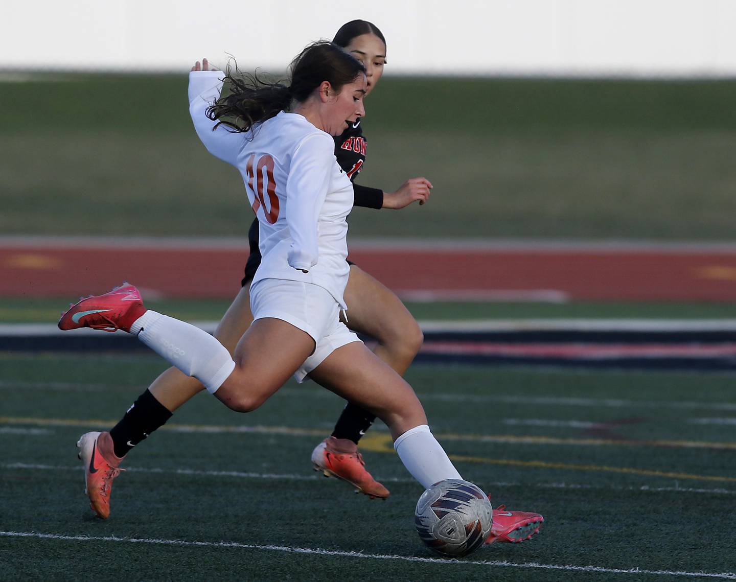 Crystal Lake Central's Addison Schaffer takes a shot at the goal as she is defended by Huntley's Itzel Martinez during a Fox Valley Conference  soccer match on Tuesday, April 15, 2025, at Huntley High School.
