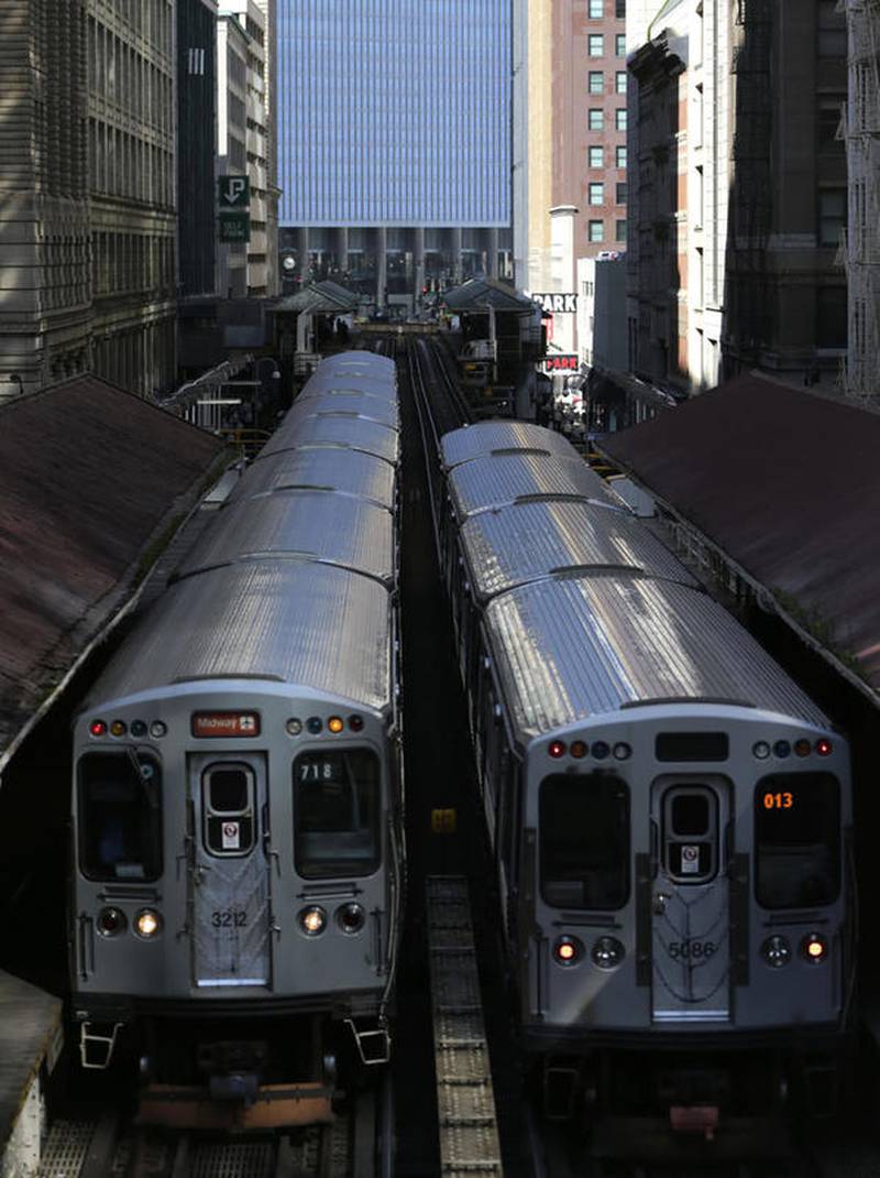 Two Chicago Transit Authority elevated trains are seen Sept. 17, 2014, above Wabash Avenue in Chicago's famed Loop. A spike in crime on Chicago's rail system and some recent high-profile outbursts of violence has prompted the city's police department to put dozens more officers in trains and on platforms, as well as assign four detectives to investigate nothing but Chicago Transit Authority crimes, officials announced Friday.