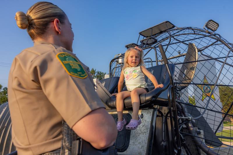 Conservation police officer Hannah Bodenbach teaches Evee Brozovich how the boat works during the National Night Out event Tuesday, Aug. 5, 2025, in Seneca.