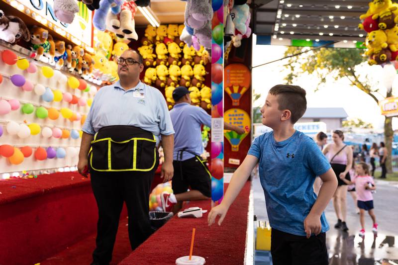 Mikey Leyendecker, 7, throws a dart in a carnival game during the 50th Bourbonnais Friendship Festival on Thursday, June 26, 2025.