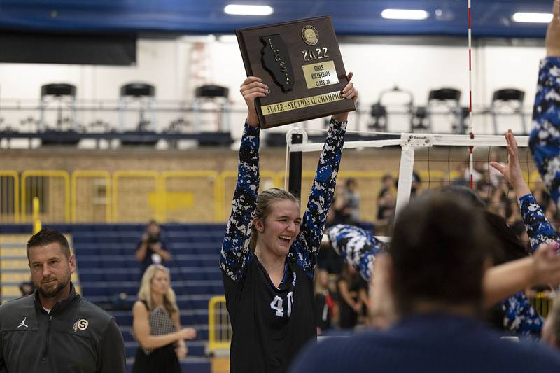 St. Francis’ Jessica Schmidt hoists the 3A supersectional plaque high after the Spartans defeated Metamora Friday, Nov. 4, 2022 in Sterling.