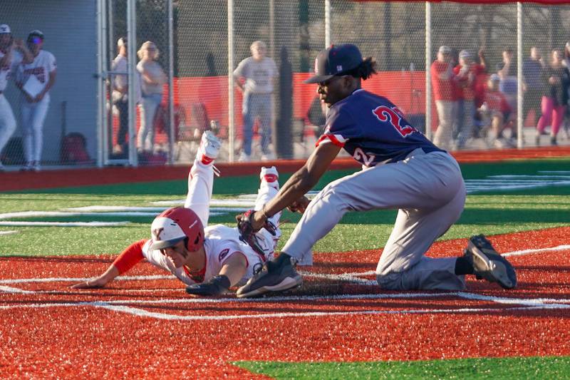 Yorkville's Sebastian Westphal (32) slides into home beating a tag attempt by West Aurora's Kaiden Williams (22) for a score during a baseball game at Yorkville High School on Monday, April 15, 2024.