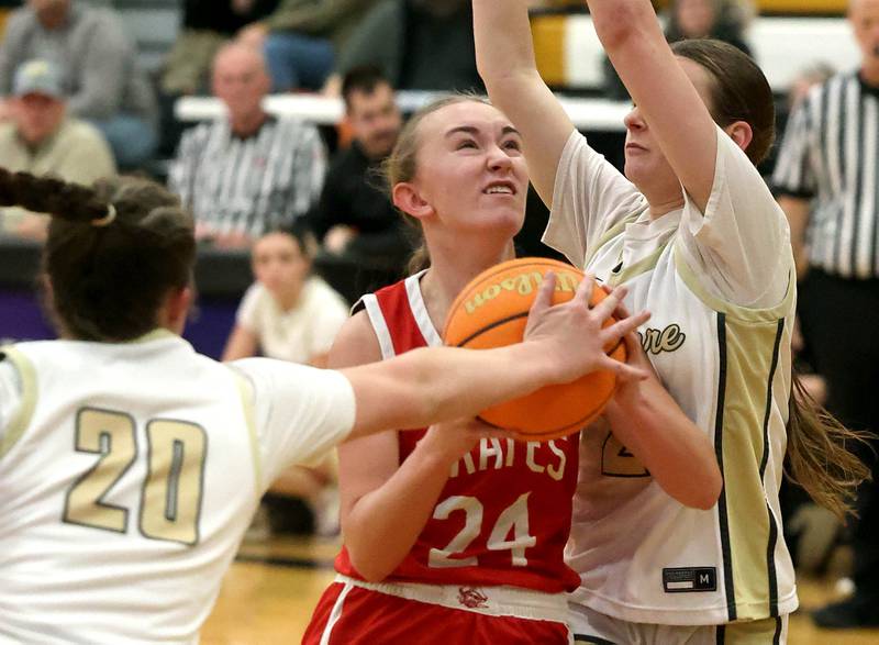 Ottawa's Ashlynn Ganiere drives between Sycamore's Callie Countryman (left) and Sydney Fabrizius during their game Friday, Jan. 10, 2025, at Sycamore High School.