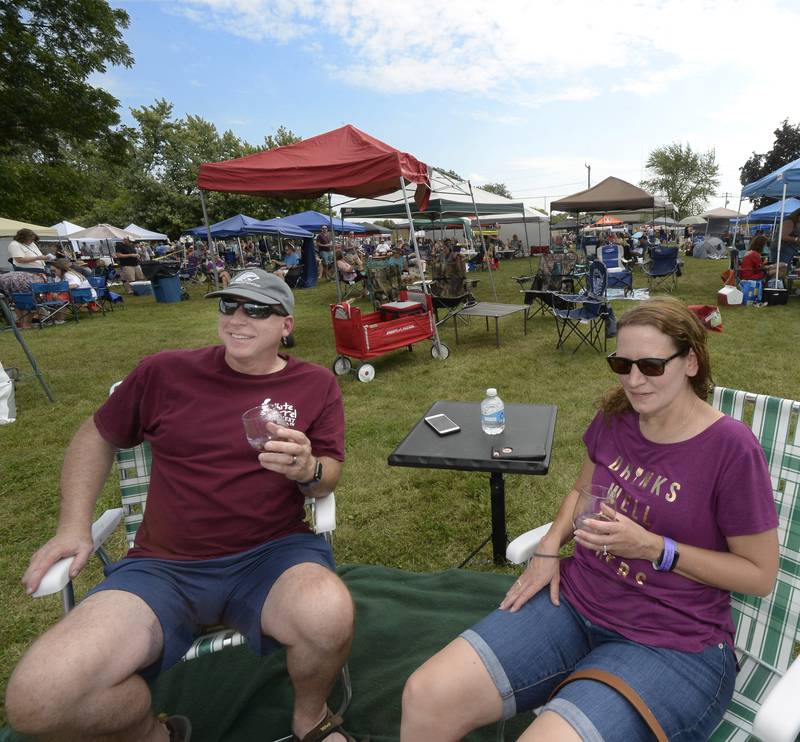 Keith and Kris Swartz, of Flanagan, along with hundreds of others, enjoy the sun and wine Saturday, Sept. 17, 2022, at Carey Memorial Park in Utica during the Vintage Wine Festival.
