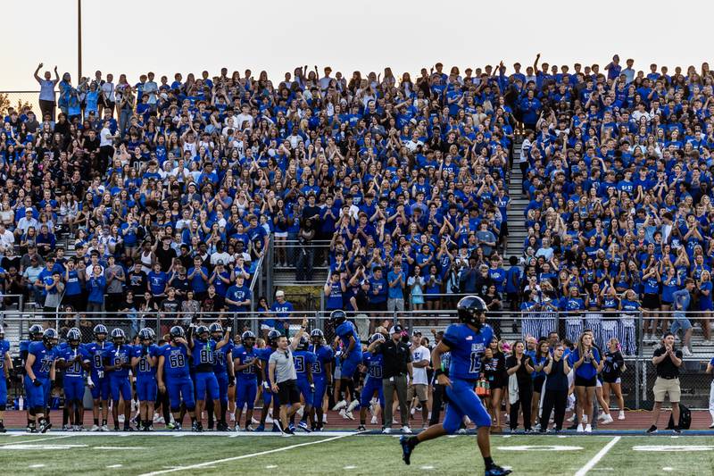 Lincoln-Way East's Jonas Williams runs to the end zone as fans cheer after Jack Murphy scores a touchdown during a varsity football game against Metea Valley at Lincoln-Way East on Oct. 3, 2025.