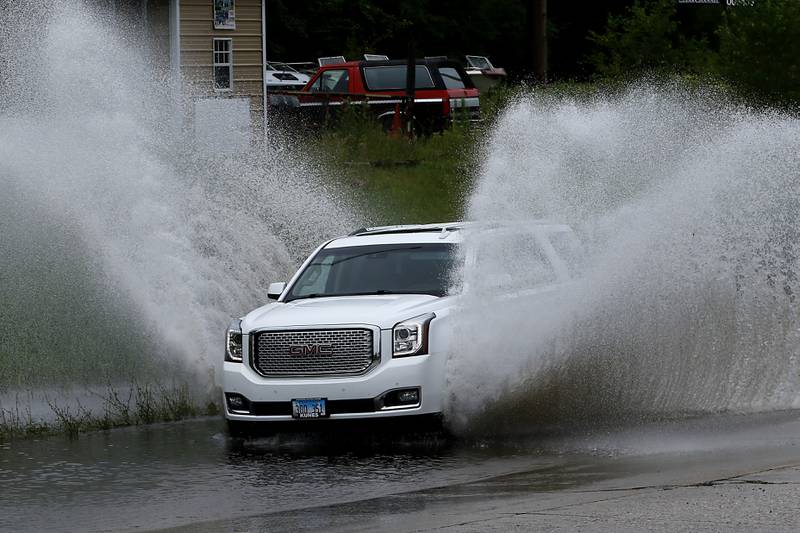 Vehicles navigate a section of high water on Illinois Route 14, near Nimco Drive, on Tuesday, June 25, 2024, after heavy rain from overnight thunderstorms.
