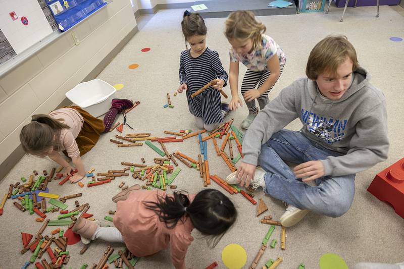 Newman Central Catholic High School junior Samuel Mauch and host of young students dig into some wooden toy logs during a period of play Thursday, Feb. 2, 2023 at St. Mary’s School in Sterling. To cap off Catholic Schools Week, schools from Dixon, Sterling and Rock Falls had an all-schools mass at Newman on Friday.