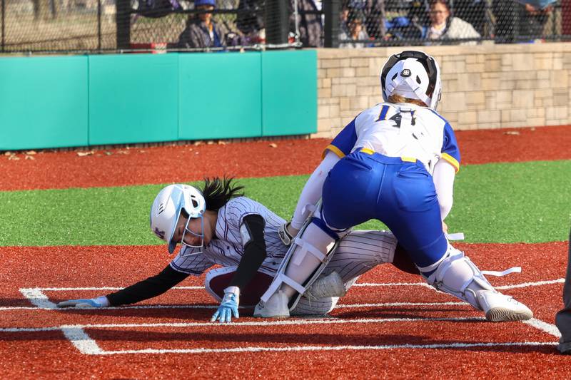 Kankakee's Lily James scores a run against Crete-Monee's Madison Myers at the plate during the Kays 20-11 loss to Crete-Monee on Tuesday, April 7, 2026.