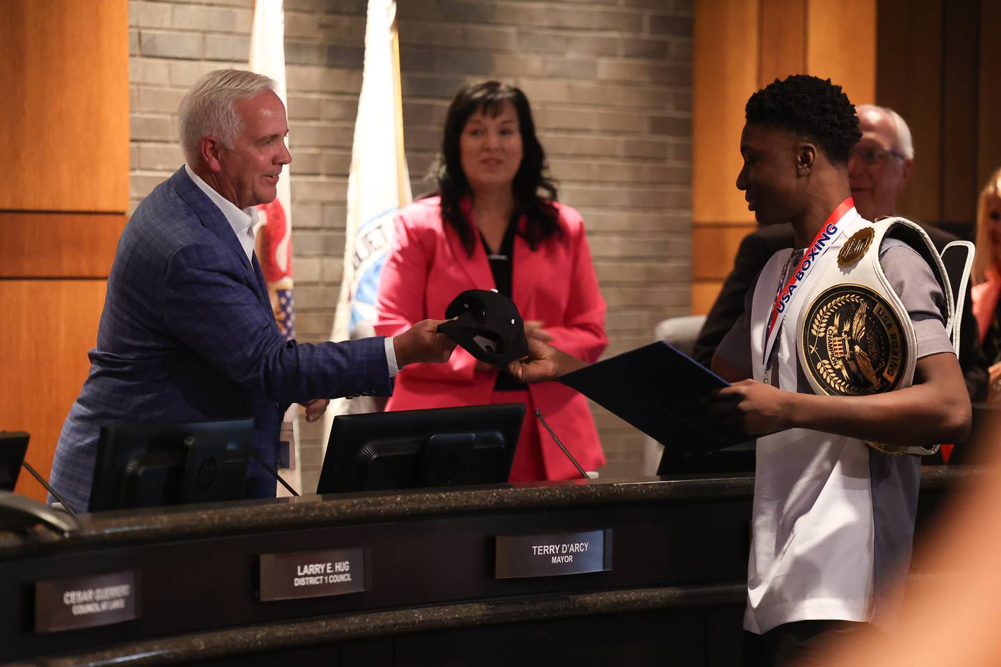 Joseph “JoJo” Awinongya Jr, 4 time Junior Olympics Champion and Joliet native, right, gives Mayor Terry D’Arcy as Team USA Boxing hat at the Joliet City Council meeting on Tuesday, July 18th, 2023.
