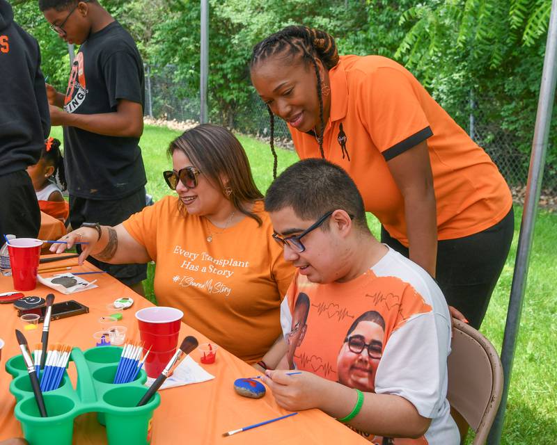 Georgina Peña (left) and her son Andy Valtierra, of Little Rock Arkansas, paint rocks and talk with Andrea Elion, mother of the late Ezra Hill Jr. on Saturday, June 7, 2025, during the Ezra Hill Jr. Memorial Foundation’s 5th annual rock painting event held at Tyler Elementary School in DeKalb. The foundation was created to memorialize the late DeKalb boy, shot and killed in 2019. Andrea had her son's heart donated to Andy in the wake of Ezra's death.