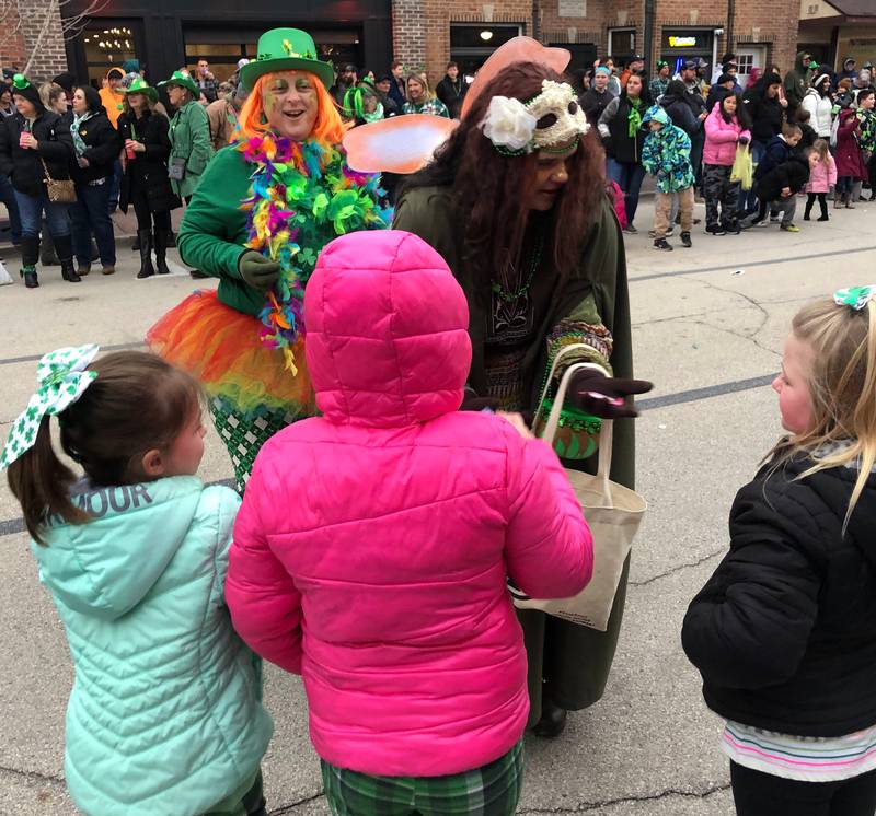 Participants in the St. Patrick's Day parade give candy to kids on Saturday, March 11 in downtown Utica.