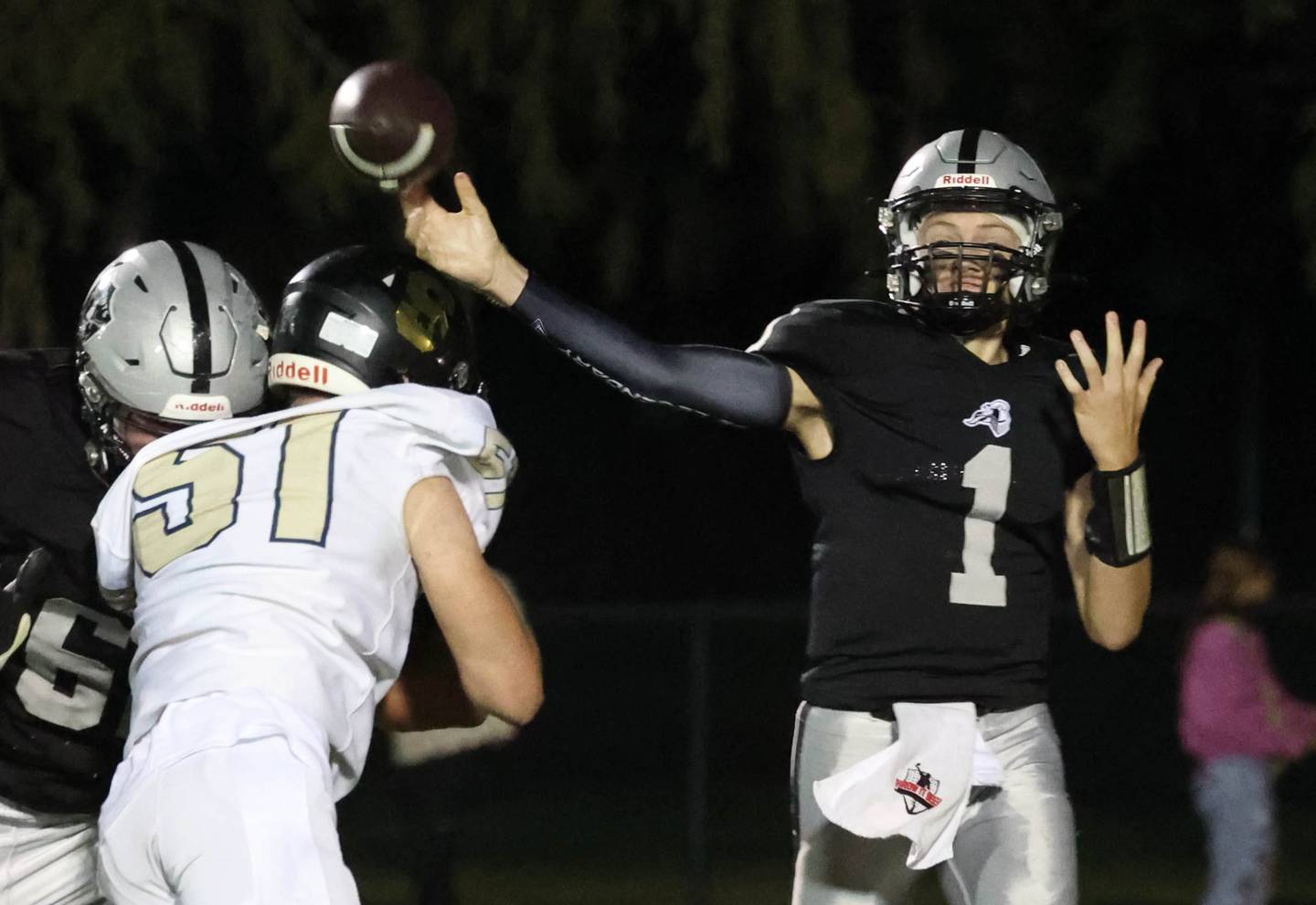Kaneland's Chase Kruckenberg throws a pass as Sycamore's Christopher  Larson tries to apply some pressure during their game Friday, Oct.4, 2024, at Kaneland High School in Maple Park.
