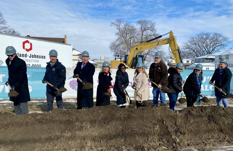 DeKalb area officials including elected leaders, staff and supporters of Safe Passage Inc., pose for a group photo on Friday, Dec. 5, 2025, at the agency's ceremonial groundbreaking to mark the start of construction on a new domestic violence survivor shelter at 217 Franklin St., in DeKalb.