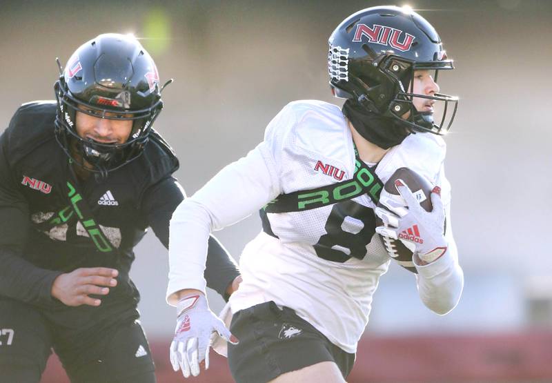 Northern Illinois University receiver Kacper Rutkiewicz carries the ball as safety Trey Porter closes in during spring practice Friday, April 7, 2023, in Huskie Stadium at NIU in DeKalb.