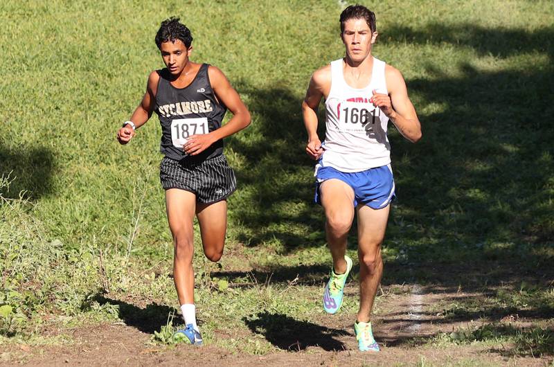 Sycamore's Naif Al Harby (left) and Glenbard South's Caleb Walter are even as they head down a hill Tuesday, Aug. 30, 2022, during the Sycamore Cross Country Invitational at Kishwaukee College in Malta.