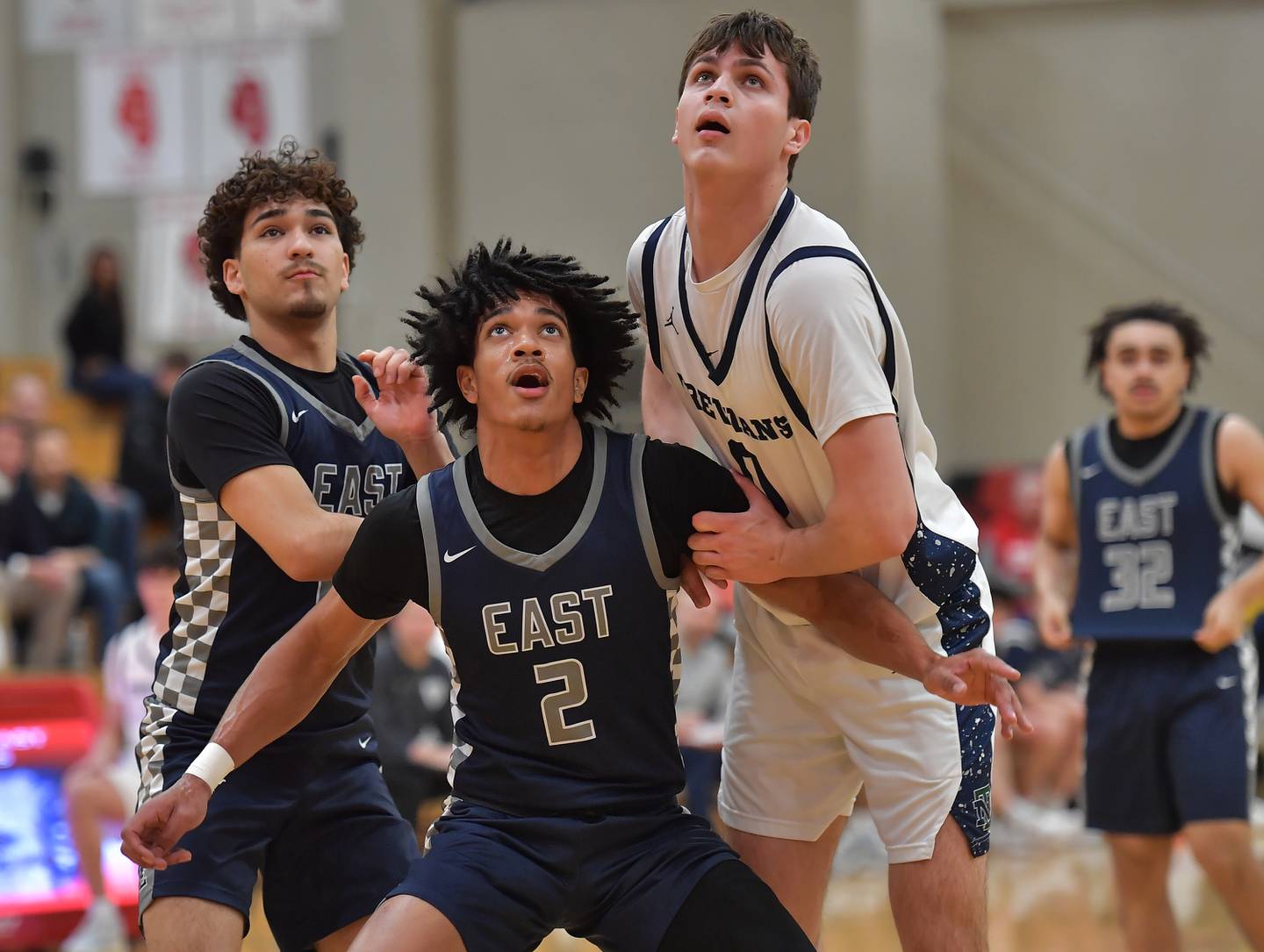 Oswego East’s Jacsen Tucker (2) and Juan Zavala tangle for rebounding position with New Trier’s Owen Foster during a When Sides Collide Shootout game on January 24, 2026 at Benet Academy in Lisle.