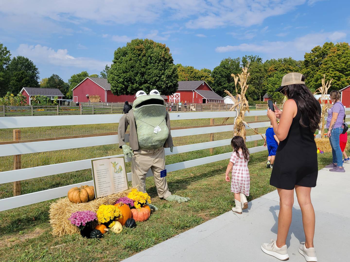 Attendees walk past a "Frog and Toad" themed scarecrow submitted by the Bradley Public Library during the Bourbonnais Township Park District's 12th annual Scarecrow Festival on Sunday, Sept. 21, 2025, at Perry Farm Park.
