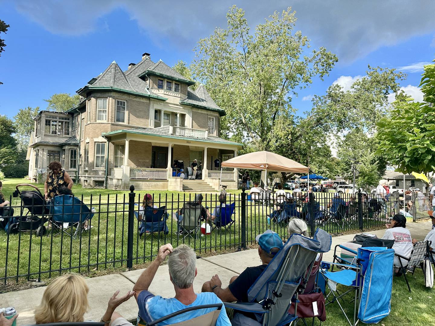 Patrons enjoy the music on a Western Ave. porch at Porch & Park Music Fest 2024