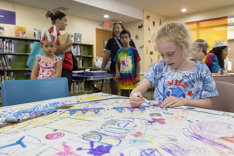 Madison McClevey, 6, works on a craft Wednesday, July 3, 2024 at the Dixon library.