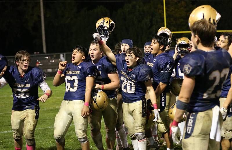 Members of the Marquette football team celebrate after defeating St. Bede 34-20 on Friday, Oct. 13, 2023 at Gould Stadium.