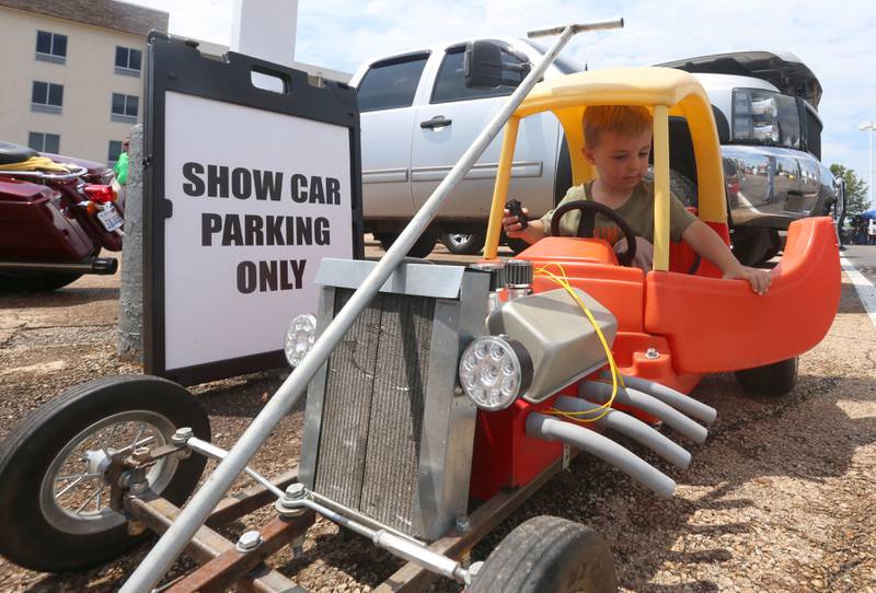 Kenny Baker of Seneca, steps into his homemade dragster built with a Fisher Price car during the Cars and Coffee Car Show on Sunday,  July 14, 2024 at Bill Walsh Kia and Ford in Ottawa.