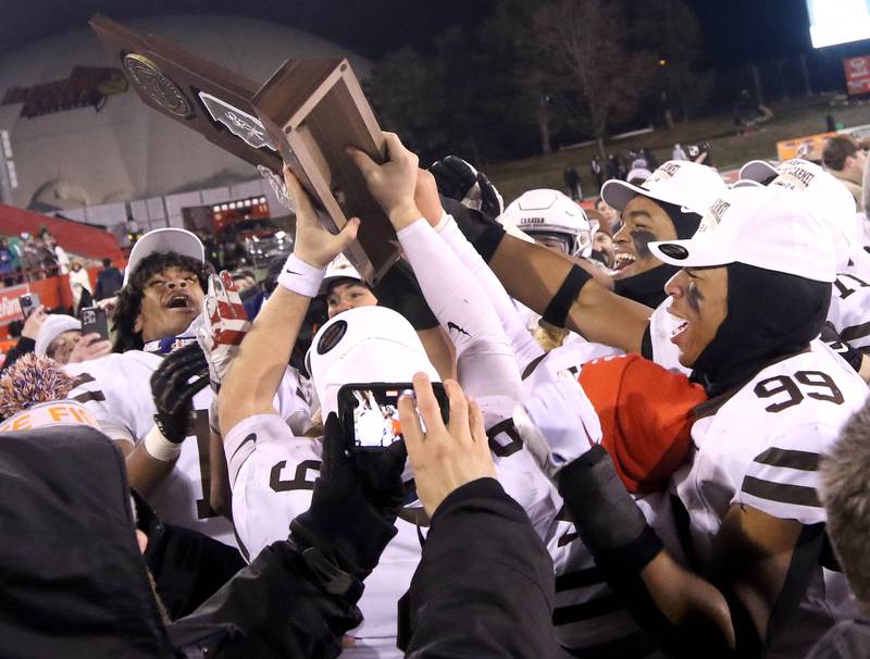 Mt. Carmel players celebrate with the trophy after their Class 8A state championship win over Batavia Saturday, Nov. 30, 2024, in Hancock Stadium at Illinois State University in Normal.