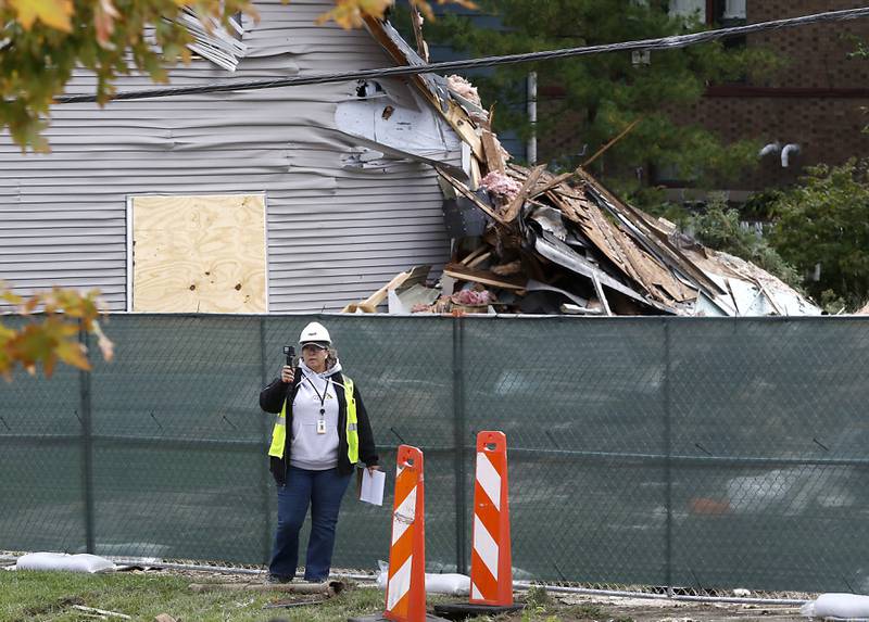 Vallerie Canfield, a claims manager at NPL Construction Co., surveys the damage in the 300 block of Lincoln Avenue on Tuesday, October 10, 2023, after an explosion following a gas leak in the area leveled one home as caused several fires.