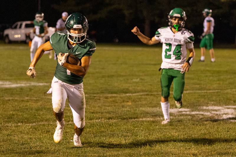 Jose De Le Torre (1) of St. Bede runs ball as Isiah Harris (24) of North Boone trails on Friday, Sept 12, 2025 at Captain Thomas J. Heitmann field in Peru.