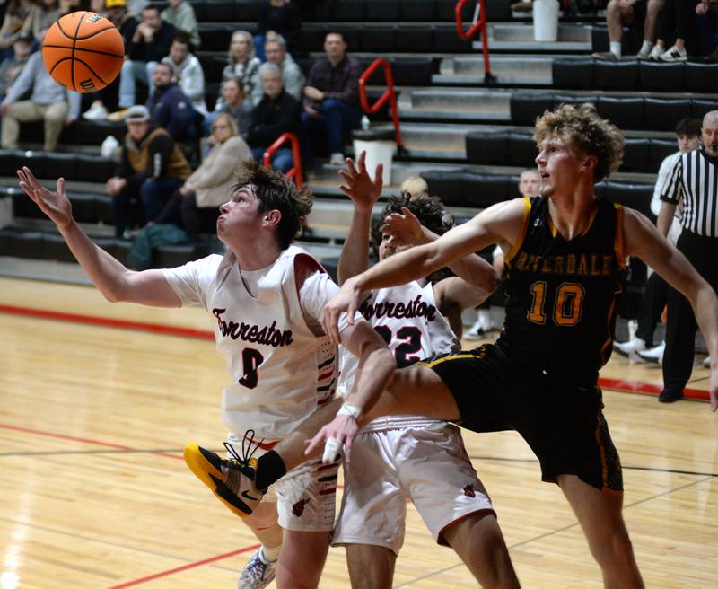 Forreston's Brandon Greenfield (0) and Jonathan Milnes (32) battle Riverdale's Brody Clark (10) for a rebound on Friday, Dec. 27, 2024 at the Cliff Warkins Memorial Basketball Tournament at Erie High School.