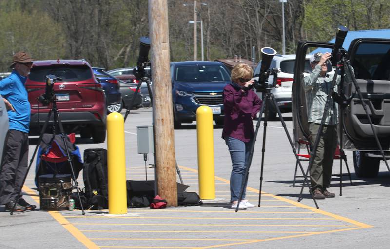 Professional photographers from Nebraska photograph the total solar eclipse in a parking lot at Rend Lake on Monday, April 8, 2024.