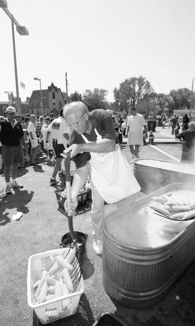 At the DeKalb Corn Boil in August 1998, police chief Don Burke served up freshly boiled corn. The corn boil started in 1957 and grew to become Corn Fest in 1977. Chuck Siebrasse, overseeing the operation at left, served as Corn Fest Board Chair from 1985-2009. In 2009, the corn boil was renamed "Chuck Siebrasse Corn Boil" in honor of his devotion to the event.