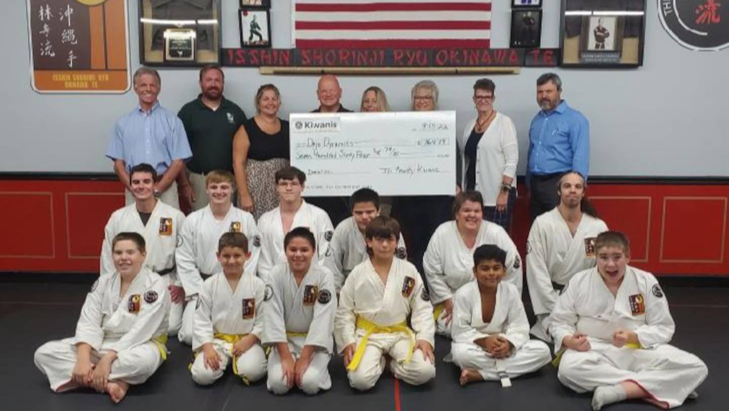 Pictured are Tri-County Kiwanis members presenting a donation to Scott Franics, owner of Dojo Dynamics, along with students of the Dojo.