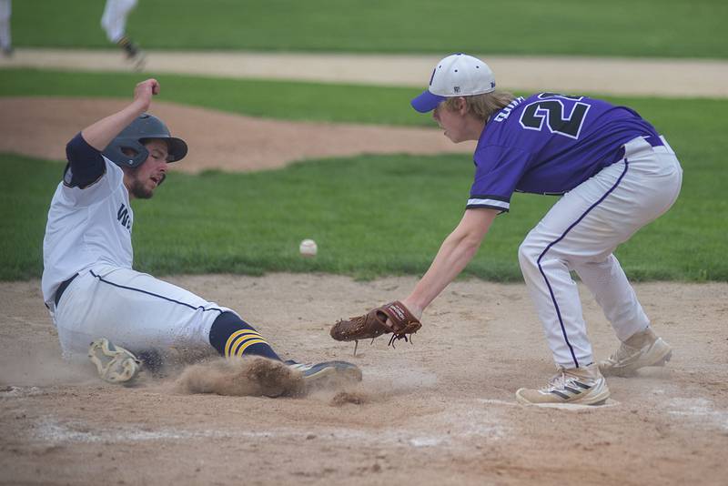 Sterling’s Blake Nettleton slides in safely against Dixon’s Kyle Adkins on a wild pitch Tuesday, May 17, 2022.