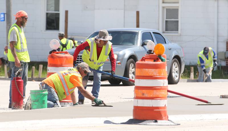 Crews use concrete trowels to smooth out surfaces of the roundabout on Tuesday, May 16, 2023 at the intersection of Illinois Route 178 and U.S. Route 6 in Utica.