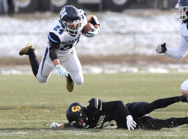Nazareth's Alexander Angulo is tripped up by Sycamore's Diego Garcia Saturday, Nov. 18, 2022, during the state semifinal game at Sycamore High School.