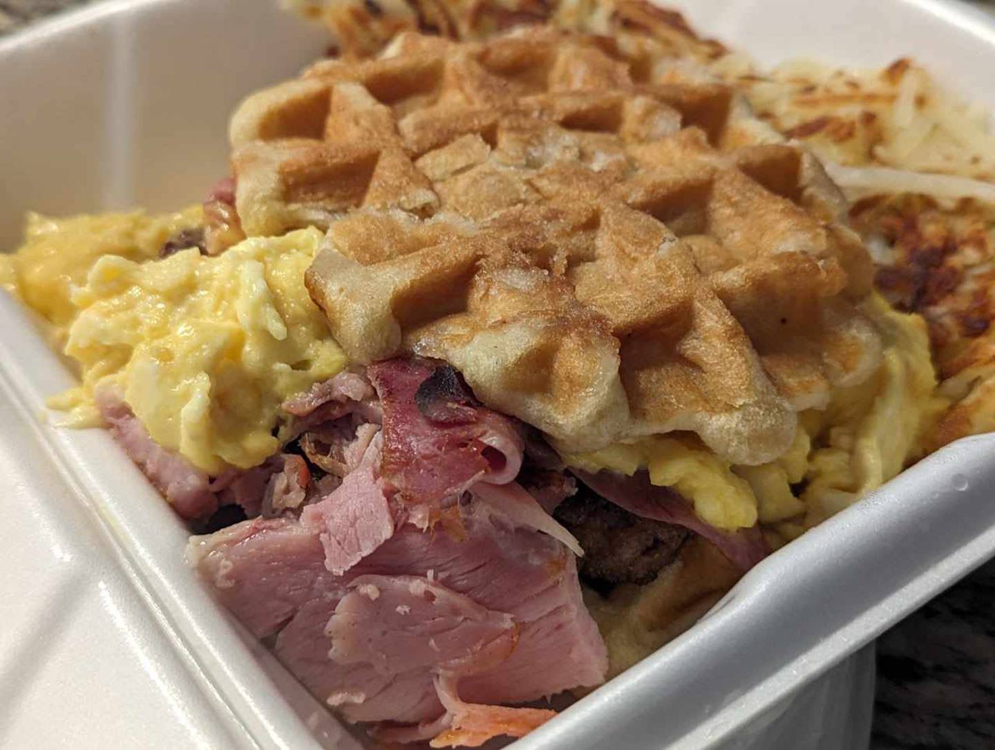 The Sugga Baby at the Southern Cafe in Crest Hill was a massive sandwich with two pearl sugar waffles glazed with maple syrup serving as bread. The filling consisted of hickory smoked bacon, house-made sausage, shaved ham slices and cheesey. scrambled eggs.
