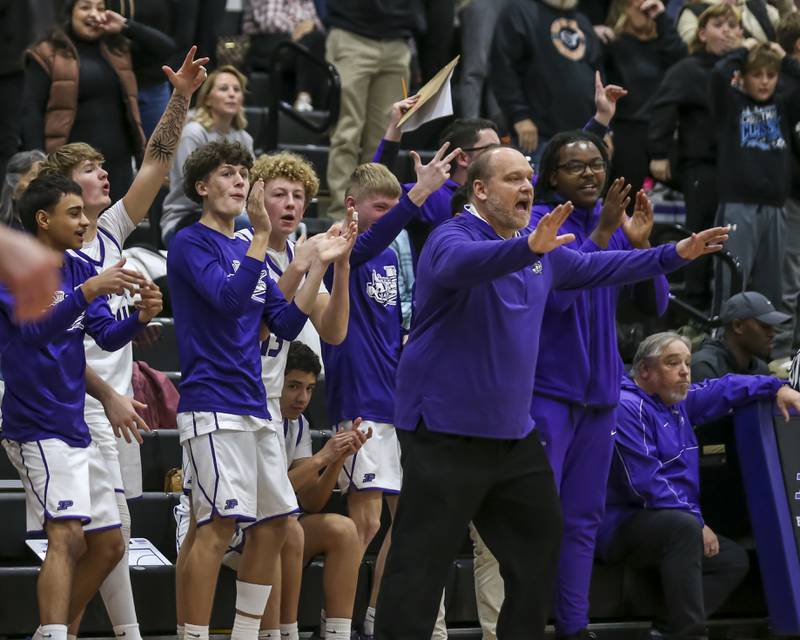 The Plano bench and coach cheers on the team during their basketball game between Sandwich at Plano Tuesday, Dec 9, 2025 in Plano.