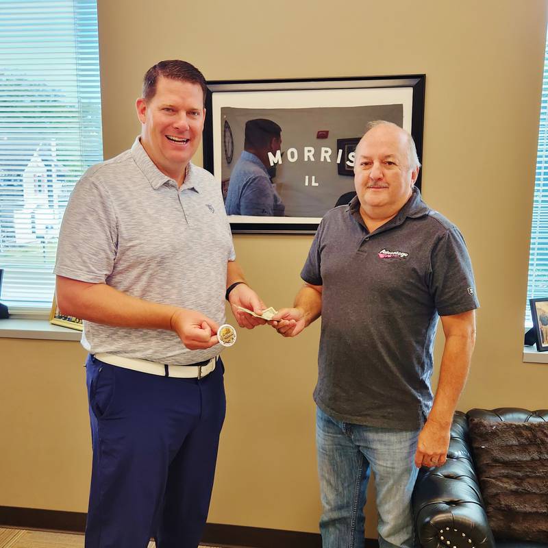 Jim Maskel sells the first button of 2023 to Morris Mayor Chris Brown.