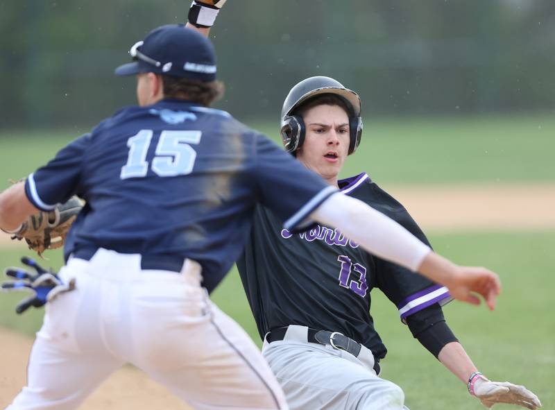 Downers Grove North's Jude Warwick (13) slides into third during the varsity baseball game between Downers Grove South and Downers Grove North in Downers Grove on Saturday, April 29, 2023.