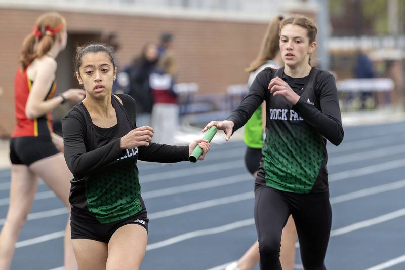 Rock Falls’ Brenna Burdock takes the baton from Ashley Rodriguez in the 4x8 Friday, May 2, 2025, at the Sterling Night Relays.