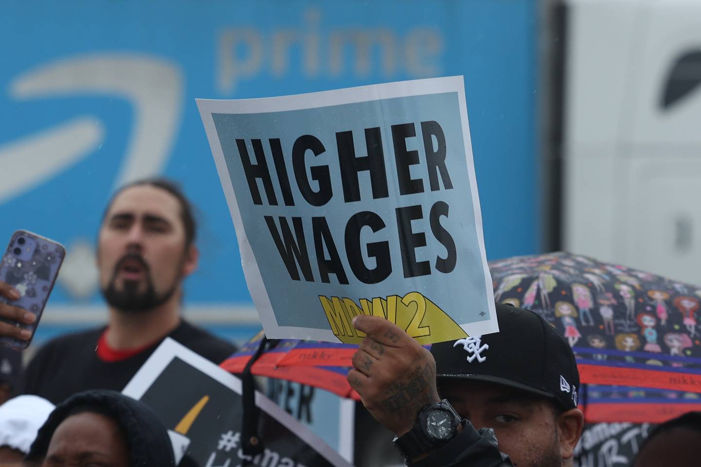 A protester holds up a sign during a staged walkout Tuesday, October 11th in Joliet. Amazon employees of MDW2 are teaming with Workers for Justice, a nonprofit organization supporting warehouse workers, to demand a safer work place and jobs that offer a living wage.