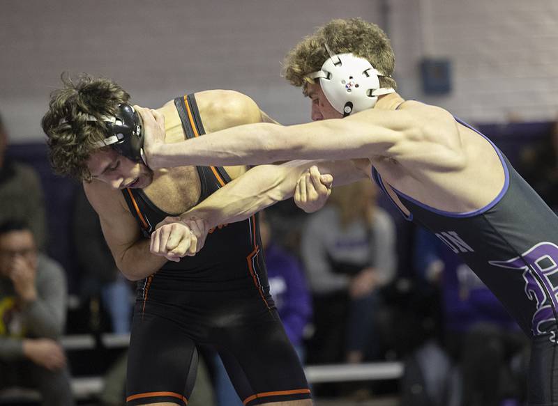 Dixon’s Charlie Connors stiff arms Freeport’s Blake Slusser Tuesday, Jan. 13, 2025, during a triangular meet with Sterling at Dixon High School.
