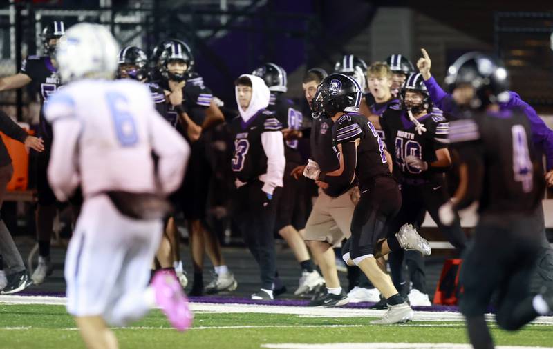 Downers Grove North's Connor Crowley (21) heads up the sidelines after picking off an interception during the IHSA Class 7A playoff football game Friday, Oct. 31, 2025 in Downers Grove.