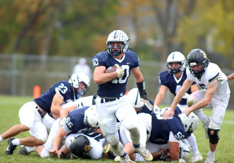 Cary-Grove’s Logan Abrams leaves a mess of Trojans and Spartans in his wake in IHSA football Class 5A first-round playoff action at Al Bohrer Field on the campus of Cary-Grove High School in Cary on Saturday, November 1, 2025.