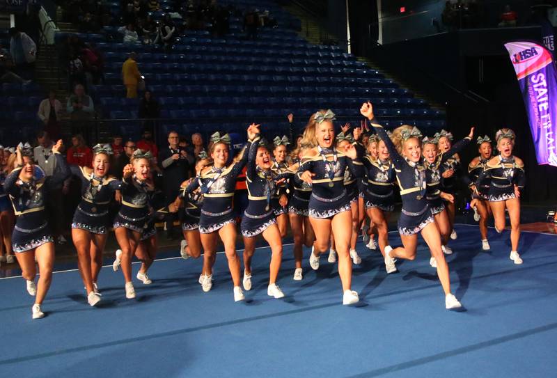 Members of the Lemont cheerleading team run to grab the first-place trophy at the Competitive Cheerleading State Final Competition on Saturday, Feb. 3, 2024 at Grossinger Motors Arena in Bloomington.