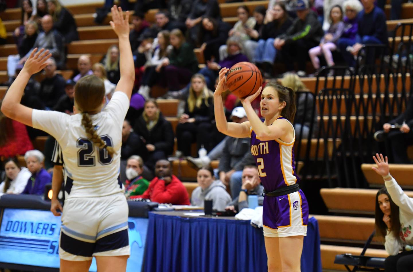 Downers Grove North's Violet Mitchell (right) shoots for three points against Downers Grove South during a crosstown game on Dec. 17, 2022 at Downers Grove South High School in Downers Grove .